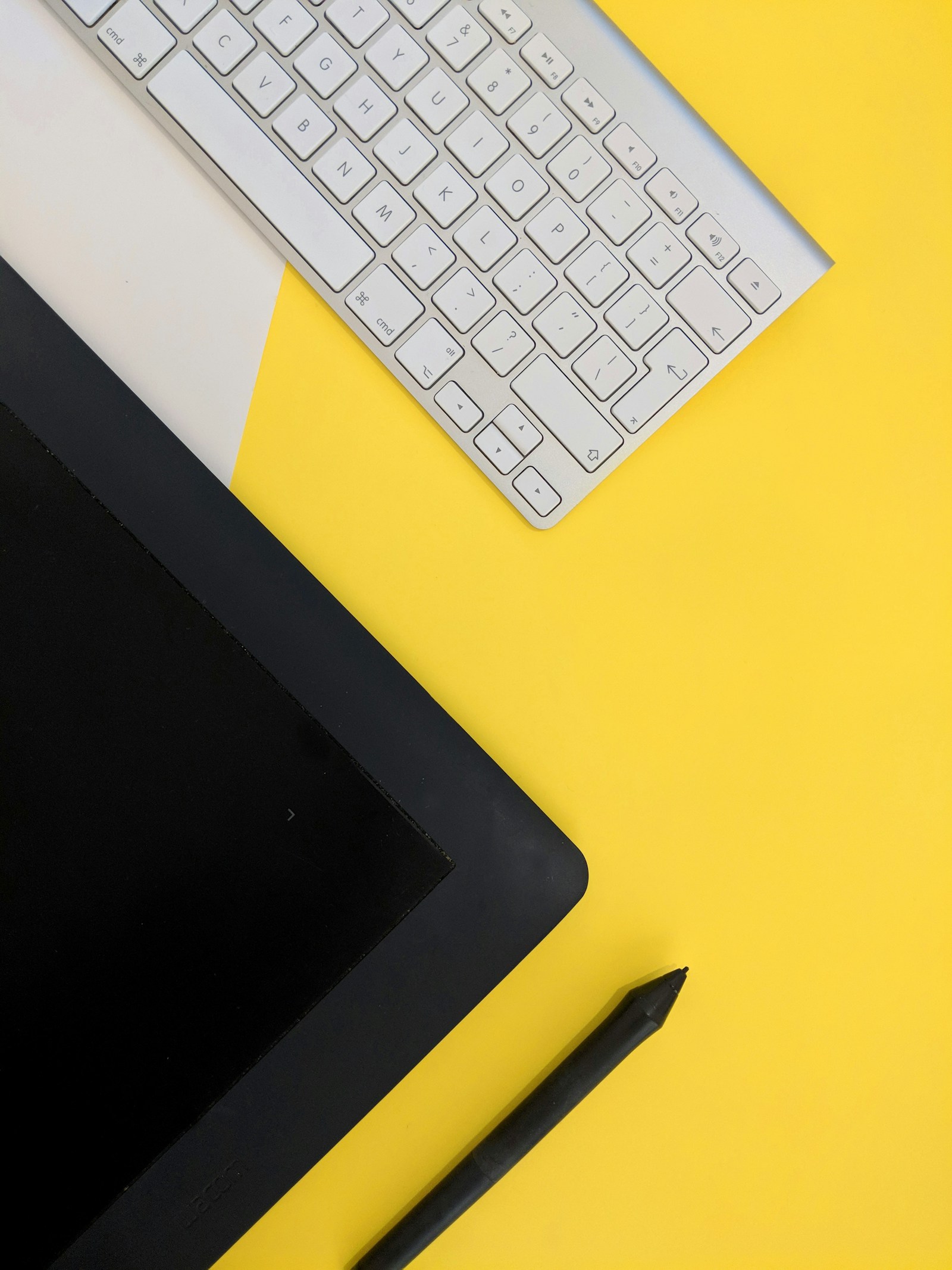 Yellow creative workspace with a keyboard and drawing tablet